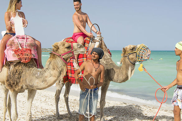 couple sur des dromadaires à la plage - Photo