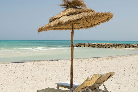 2 transats et parasol sur la plage - Photo